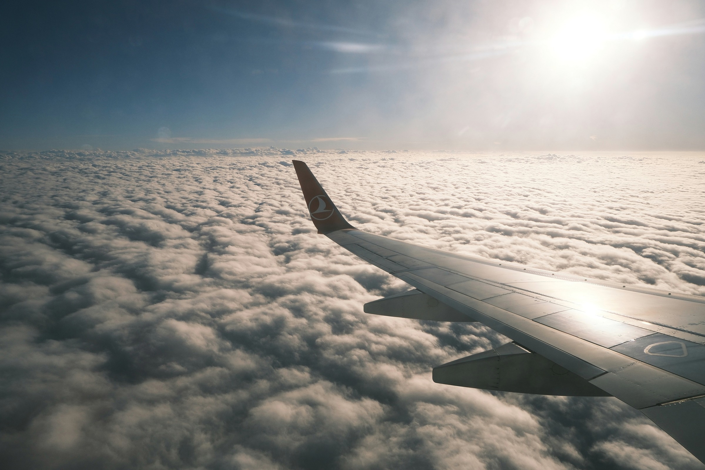 Aircraft wing above a field of clouds