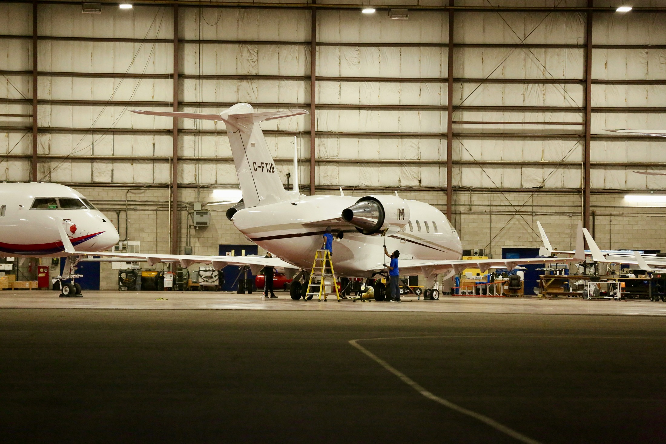 Business aircraft undergoing work inside an aviation hangar